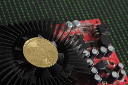 A bitcoin gold coin on a cooling fan against the background of binary code. selective focus.の写真素材