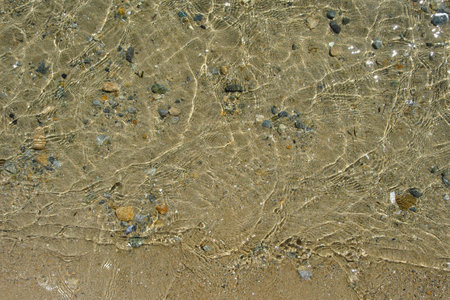 The sandy bottom of the sea with the purest transparent water with sun glare on the waves. abstract background. selective focus.の写真素材