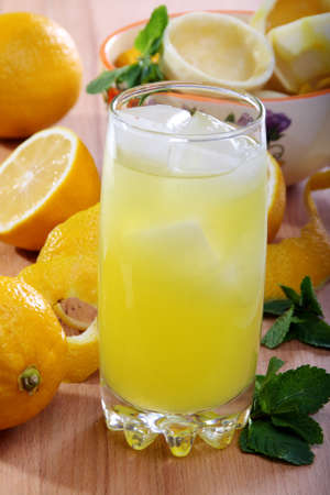 Lemonade from fresh lemons, ice and mint on a wooden table.の写真素材