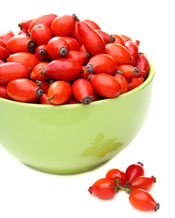 Rose hips in a ceramic bowl on a white background.の写真素材