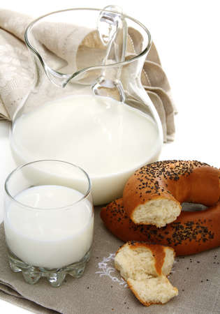 Bagel with poppy seeds a pitcher of milk on a white background.の写真素材