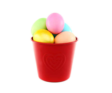 Easter eggs in red bucket on a white background.の写真素材