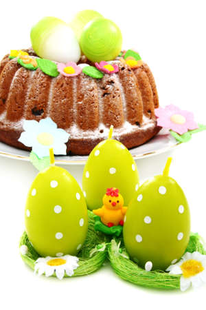 Easter candles in the sockets and the cake on a white background.の写真素材