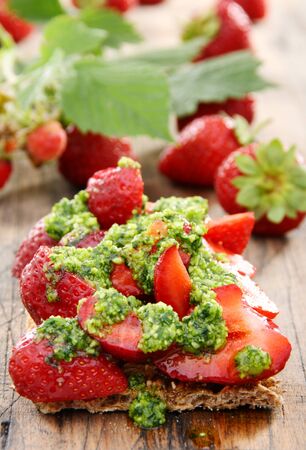 Strawberry toast with pesto and fresh strawberries on the wooden table.の写真素材