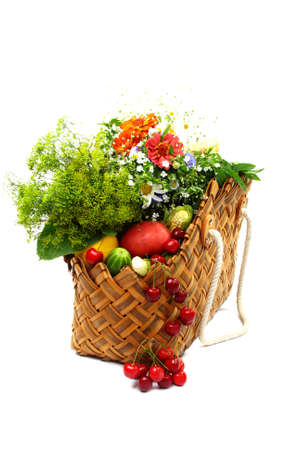 Summer fruits, vegetables and flowers in a basket on a white background.の写真素材