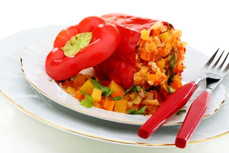 Red peppers stuffed with vegetables with turkey on a white plate の写真素材