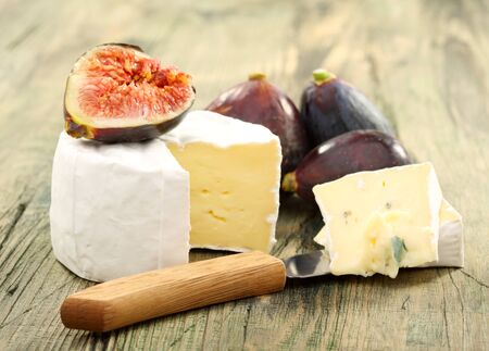 Cheese and fresh figs on a wooden board の写真素材