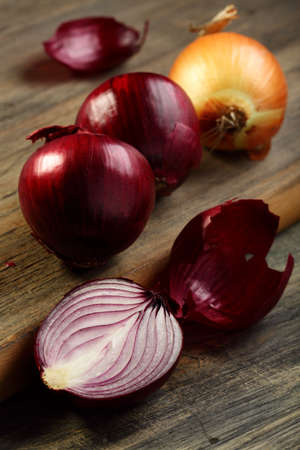 Onion red and gold on the old wooden table  の写真素材