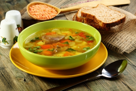Soup of chicken giblets and red lentils in a green bowl の写真素材