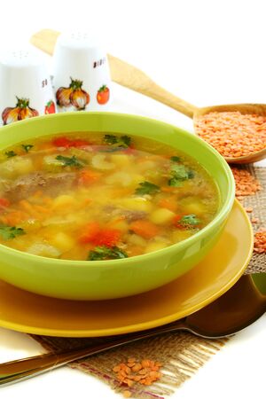 Soup with chicken giblets in green plate on a white background  の写真素材