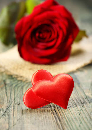 Two red hearts and roses on a wooden board の写真素材
