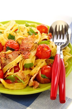 Pasta with bacon, tomatoes and basil on a white background の写真素材