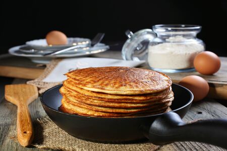  Oatmeal pancakes in frying pan on a wooden table 