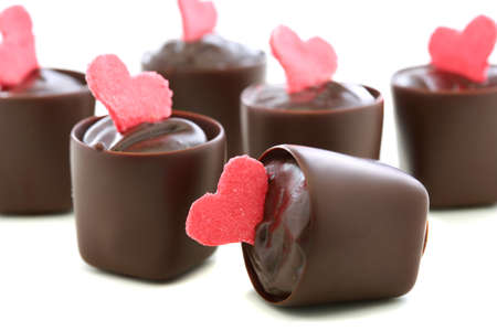 Chocolates with red hearts on a white background の写真素材