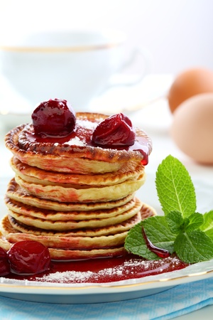Pancakes with cherry sauce and a sprig of mint  の写真素材
