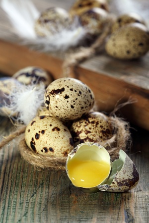 Broken quail egg on a wooden table  の写真素材