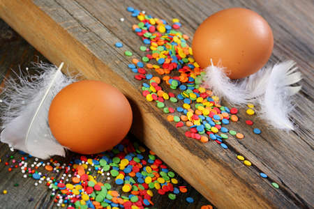 Eggs, feathers and Easter decorations on a wooden table 