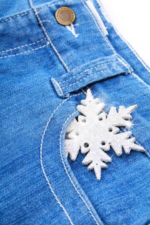 Snowflake and blue jeans on a white background.の写真素材