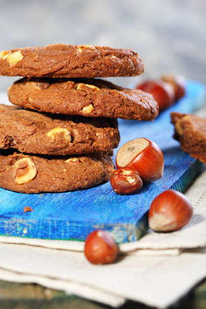 Chocolate cookies with hazelnuts on a blue board.の写真素材