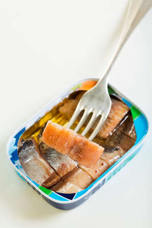 Open the can and slice of herring on a fork.