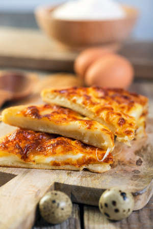 Pieces of delicious pie with cheese on a wooden board.の写真素材