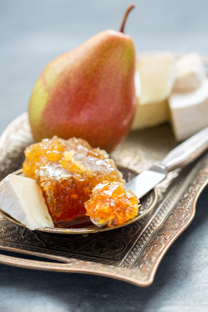 Delicious breakfast - brie, honey and pear on a metal tray.の写真素材