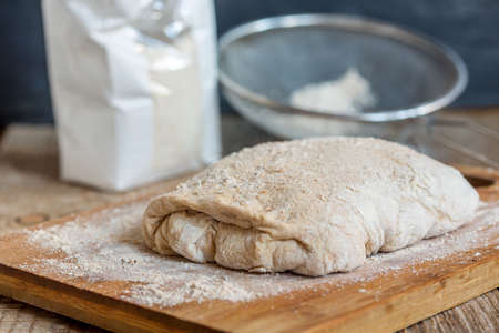 Dough for homemade bread on a wooden table.