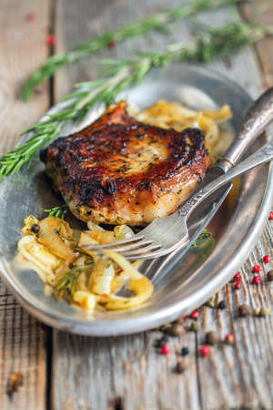 Dish with a pork chop on a wooden table.の写真素材