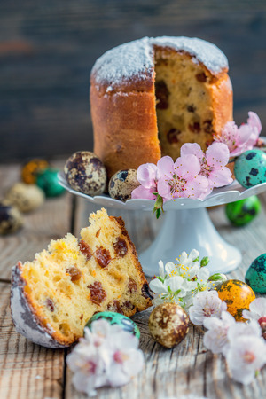 Easter cakes, eggs and blooming branch plums on a wooden table.の写真素材