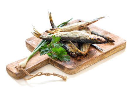 Hot smoked fish and parsley on a wooden board.の写真素材