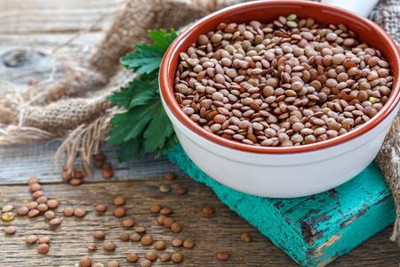 Lentils vegetarian food in ceramic bowl on a wooden table.の写真素材