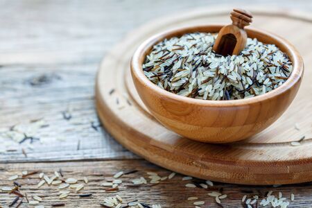 Bowl of wild and white rice on an old wooden table.