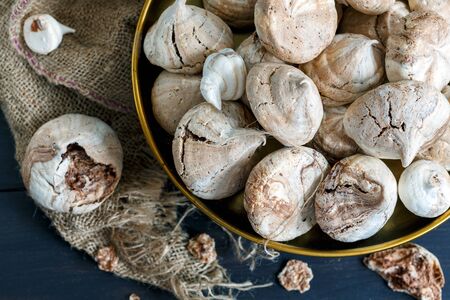 Bronze tray with chocolate meringue and old sackcloth on a dark background.の写真素材