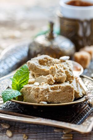 Halva of sunflower seeds on a tray with coffee, selective focus.の写真素材