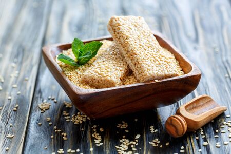 Bowl with honey sesame bars on the old wooden table.の写真素材
