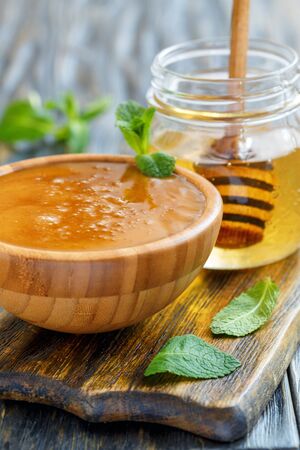 Flower honey in bowl and glass jar with linden honey, selective focus.の写真素材