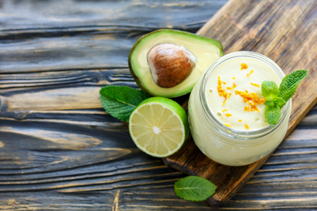 Smoothie of avocado, banana and yogurt in glass jar on wooden table, selective focus.の写真素材
