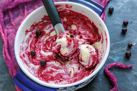 Homemade ice cream with black currants and spoon the ice cream into a ceramic pot.の写真素材