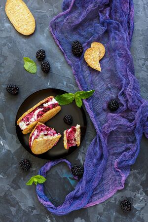 Homemade ice cream cookie sandwiches and blackberries on a stone background, selective focus.の写真素材