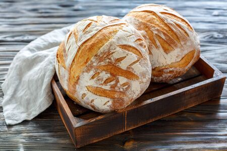 French bread on the starter on an old wooden tray with a linen napkin.