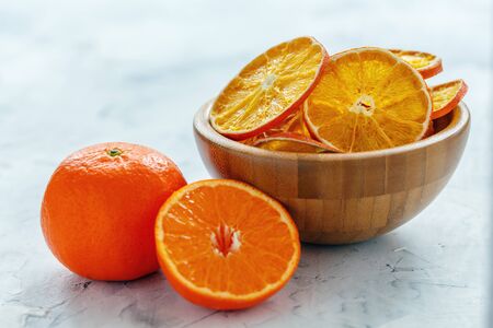 Bowl of dried orange and lemon slices on a white stone table, selective focus.の写真素材