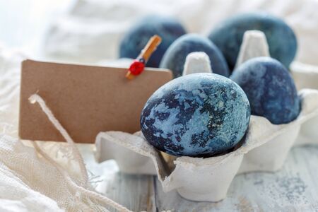 Blue Easter eggs in tray on white table, selective focus.の写真素材