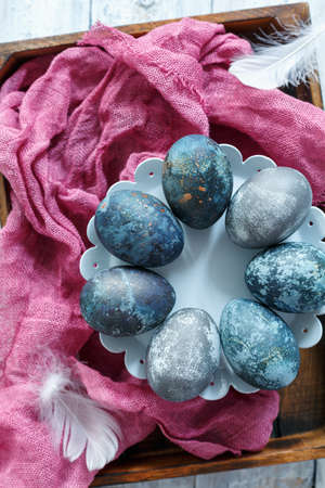 Easter eggs on the stand and linen cloth in a wooden box.