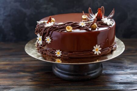 Delicious cake with chocolate frosting on a dark background. Shallow focus.