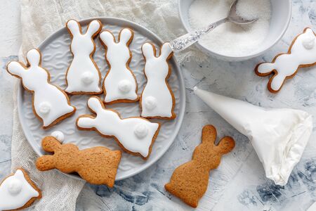 Homemade Easter cookies in the shape of bunny on a white stone table.の写真素材