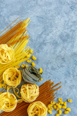 Traditional Italian pasta of durum wheat on a grey concrete background. Top view.の写真素材