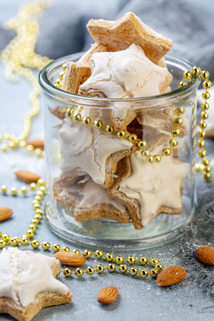 Jar of homemade German cinnamon cookies in the shape of a star on a grey concrete background. Top view.の写真素材