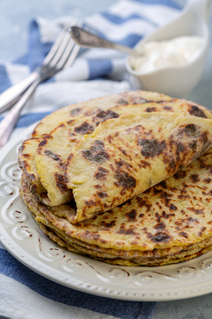 Freshly baked potato pancakes in a plate on a gray textured background, selective focus. Traditional Norwegian cuisine.の写真素材