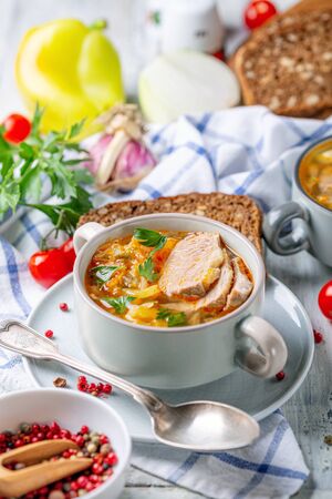 Traditional soup of fresh cabbage, vegetables and meat in a ceramic bowl on a homespun linen napkin, selective focus. Russian cuisine.の写真素材