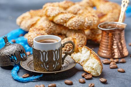 Turkish black coffee served in traditional ceramic cup with sesame bagel, selective focus.の写真素材